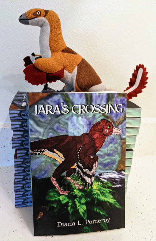 Plush Iara (by Palaeoplushies) sits atop a stack of paperback copies of 'Iara's Crossing'